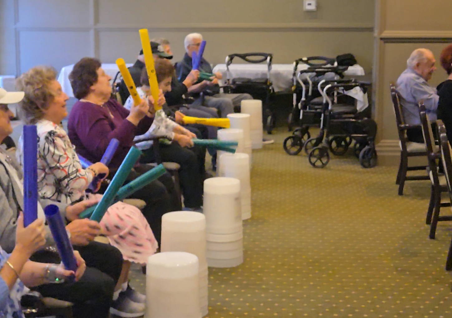 A joyful group drumming together in a cardio drumming session