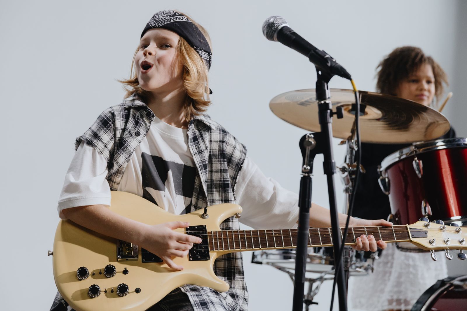 Teen musicians on electric guitar and drums in a Rock Band
