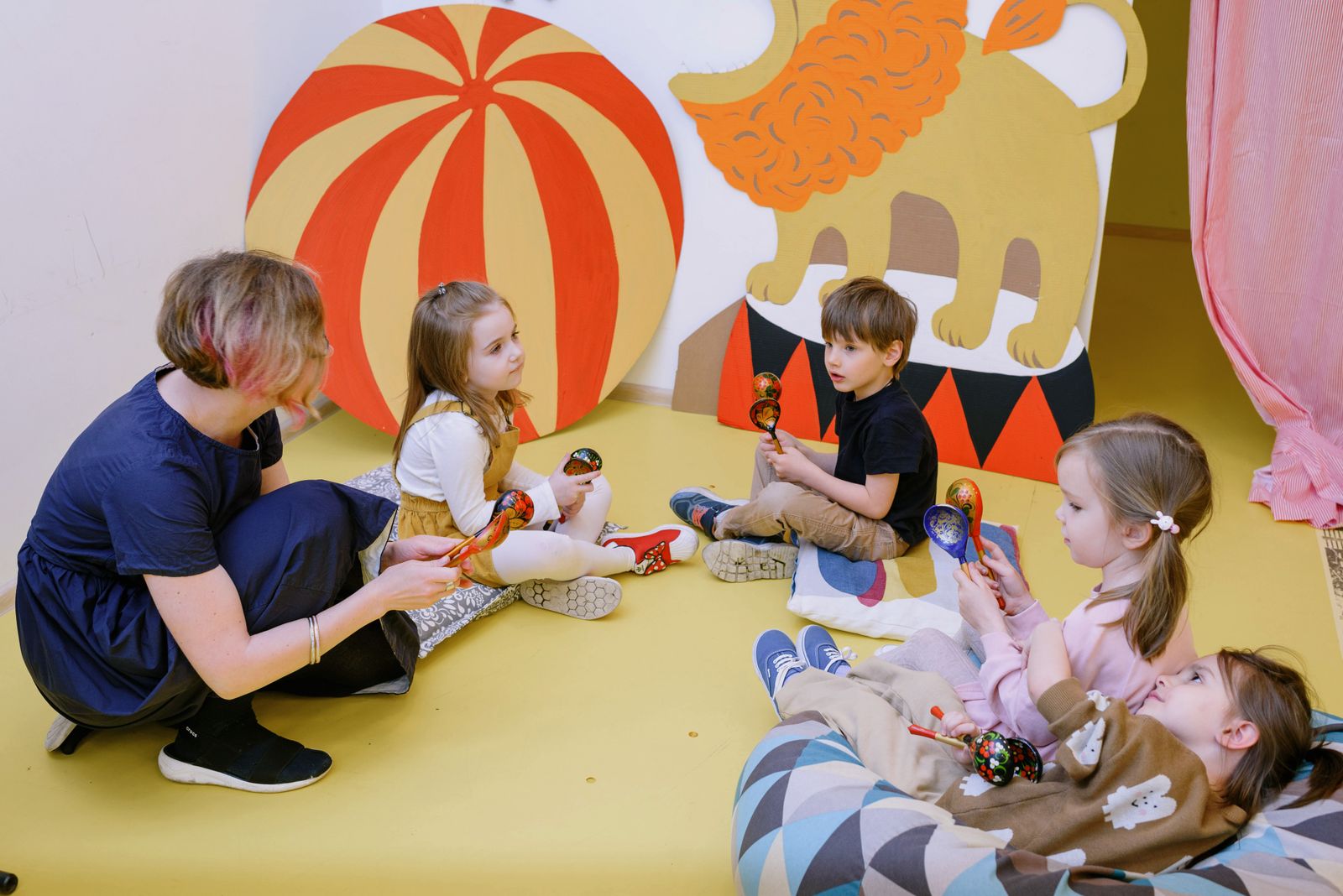 Preschoolers keeping a beat with shakers in a music circle